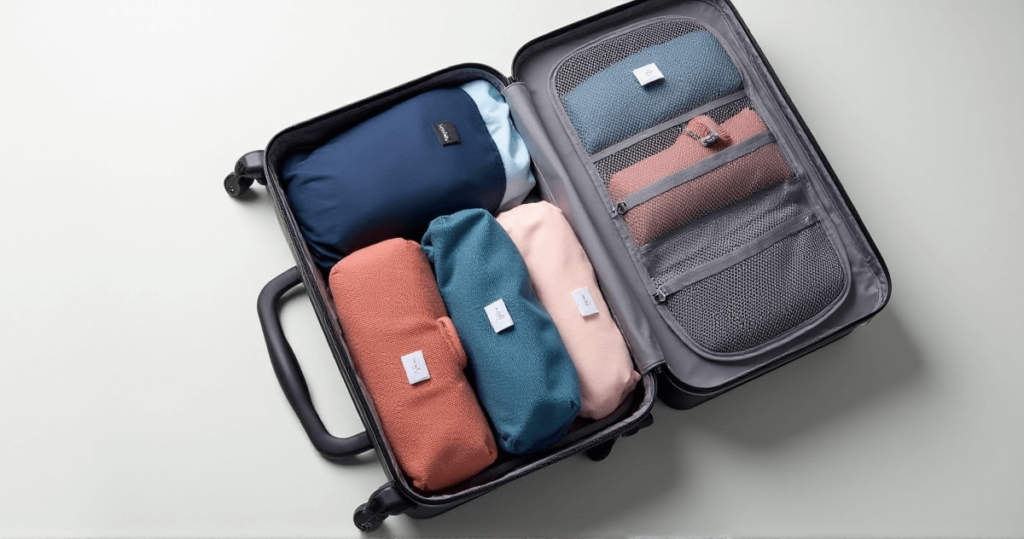 a suitcase with different colored clothes showing Packing Hacks for Travel Organization